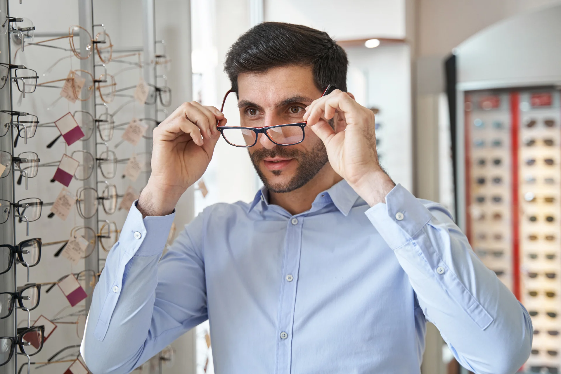 Un homme choisi des lunettes au magasin Les P'ti Opticiens à Bourg-lès-Valence